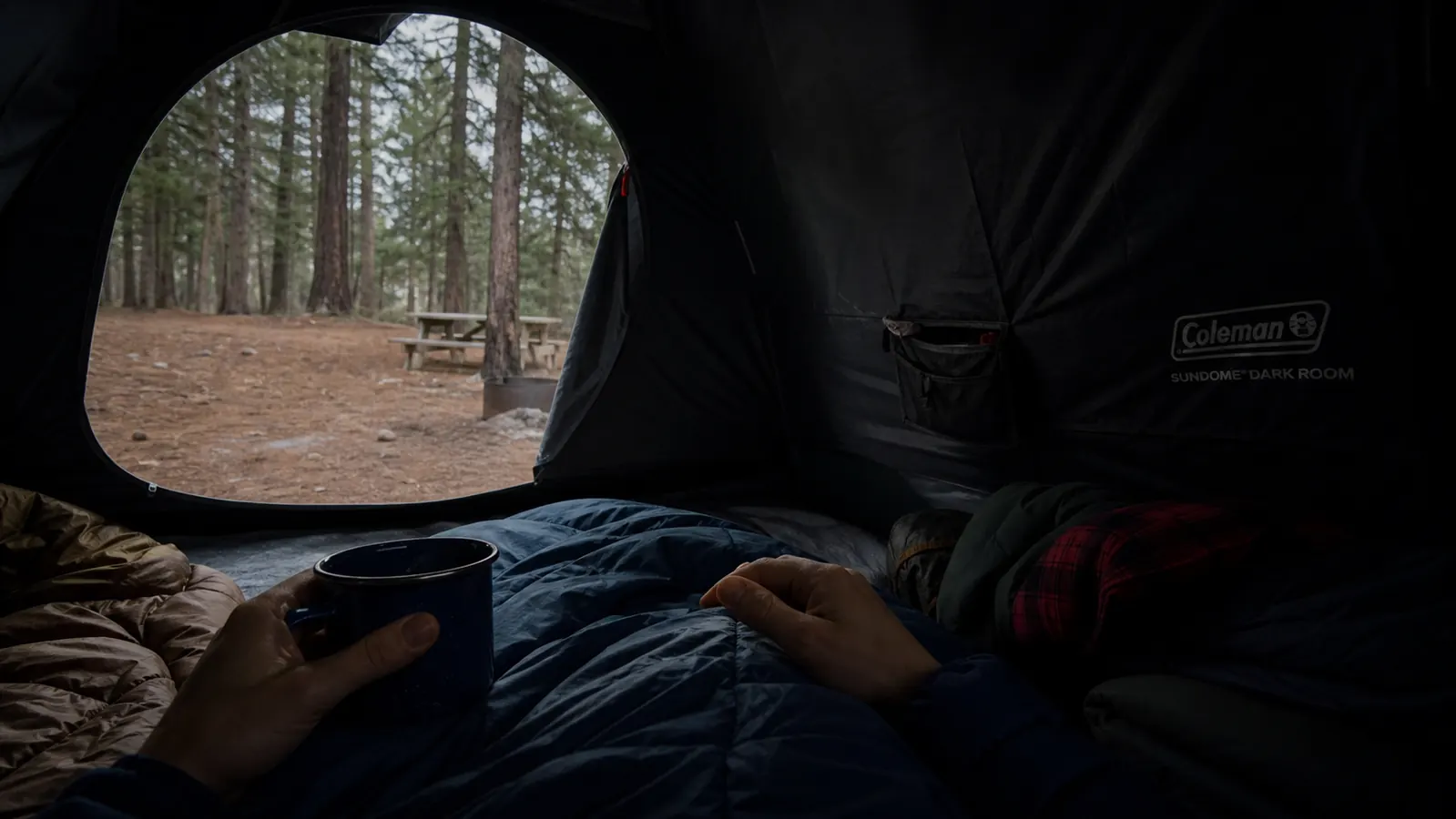 Interior of a dark room tent showing blackout fabric panels blocking morning sunlight